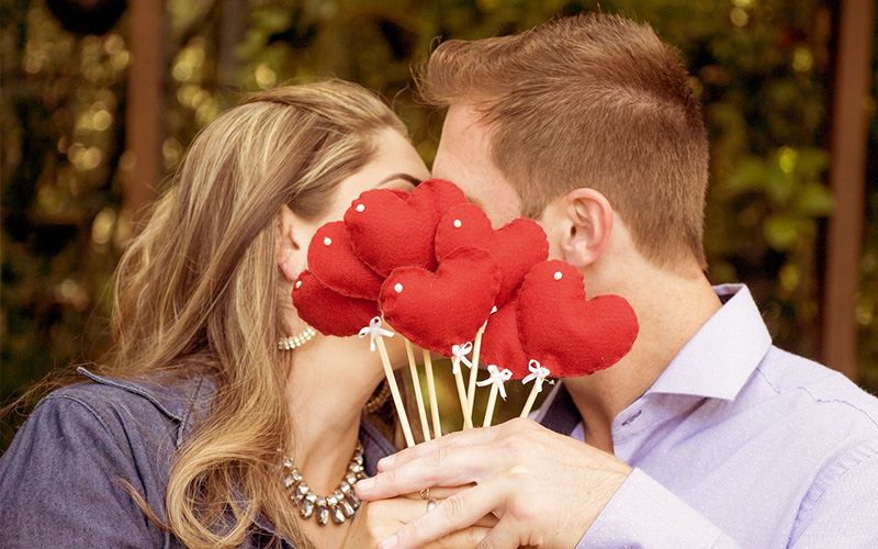 ハートで顔を隠す男女